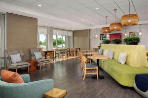 a lobby with a green couch and tables and chairs at Home2 Suites by Hilton - Memphis/Southaven in Southaven