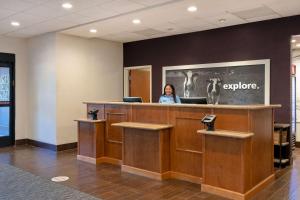 a woman standing at a reception desk in a lobby at Hampton Inn & Suites Rohnert Park - Sonoma County in Rohnert Park