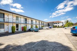 um edifício com carros estacionados num parque de estacionamento em The Mulgrave Motel em Mulgrave