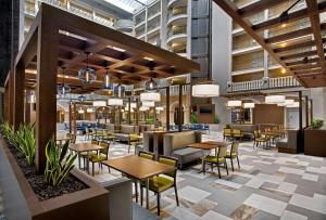 a rendering of a restaurant with tables and chairs at Embassy Suites by Hilton Orlando International Drive Convention Center in Orlando