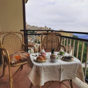 einen Tisch mit einem Teller Essen auf dem Balkon in der Unterkunft B&B La Finestra Sul Mare in Ripatransone