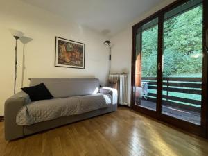 a living room with a couch and a sliding glass door at 026 Bilocale con caminetto, Giustino in Giustino