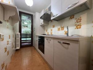 a kitchen with white cabinets and a sink at 026 Bilocale con caminetto, Giustino in Giustino