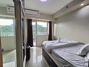 een slaapkamer met een bed en een balkon bij PREMIERE HAVEN at Shell Residences in Manilla
