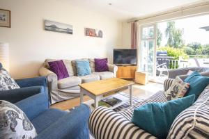 a living room with couches and a table at Isis Lakes 40 - Casa Angela in South Cerney
