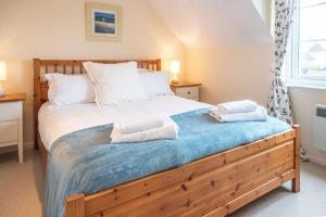 a bedroom with a large bed with two towels on it at Isis Lakes 40 - Casa Angela in South Cerney