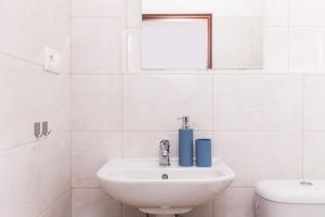 a white bathroom with a sink and a toilet at Dvojizbový byt blízko centra - 24h self check-in in Banská Bystrica
