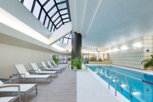 una piscina con sillas blancas y una piscina en Hilton Tokyo Hotel en Tokio