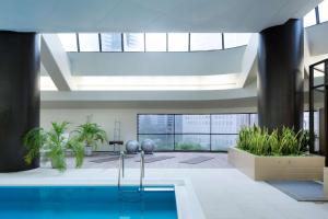 een lobby met een zwembad en een gebouw bij Hilton Tokyo Hotel in Tokyo