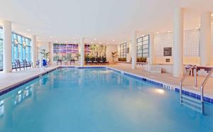 a large swimming pool with blue water in a building at Embassy Suites Parsippany in Parsippany