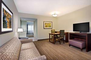 a hotel room with a bed and a desk with a television at Embassy Suites Parsippany in Parsippany