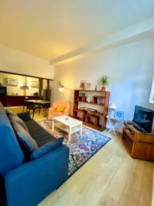 a living room with a blue couch and a table at Appartement au cœur du vieux Rouen in Rouen