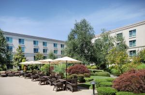 un patio con sillas y sombrillas frente a un edificio en Hilton Seattle Airport & Conference Center, en SeaTac