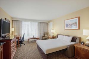 a hotel room with a bed and a flat screen tv at Hilton Seattle Airport & Conference Center in SeaTac