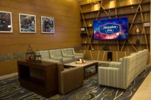 a lobby with couches and a tv in a room at Hampton Inn by Hilton Merida in Mérida