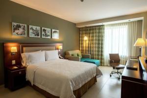 Pokój hotelowy z łóżkiem i krzesłem w obiekcie Hampton Inn by Hilton Merida w mieście Mérida