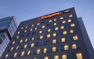 a building with a sign on top of it at Hampton by Hilton Minsk City Centre in Minsk