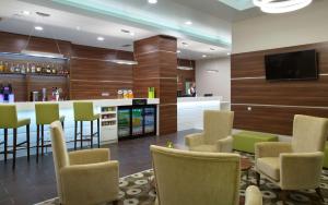 a lobby with a bar with chairs and a tv at Hampton by Hilton Minsk City Centre in Minsk