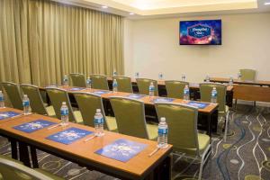 una sala conferenze con tavoli e sedie e bottiglie d'acqua di Hampton Inn by Hilton Merida a Mérida