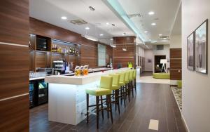 a lobby with a bar with yellow stools at Hampton by Hilton Minsk City Centre in Minsk