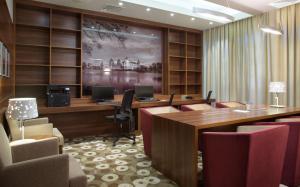 a conference room with desks and chairs and a large screen at Hampton by Hilton Minsk City Centre in Minsk