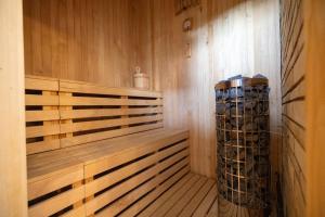 a sauna with a wooden bench and a stack of logs at Chalupa Beliankovo in Ždiar