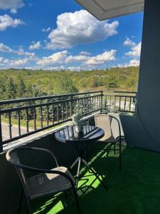 einen Balkon mit einem Tisch und Stühlen in der Unterkunft Тристаен апартамент Park View in Targowischte