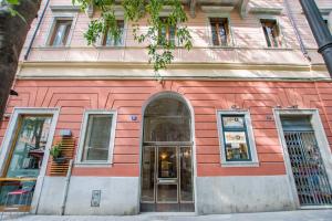 un edificio rosa con una porta davanti di Viale 24 a Trieste