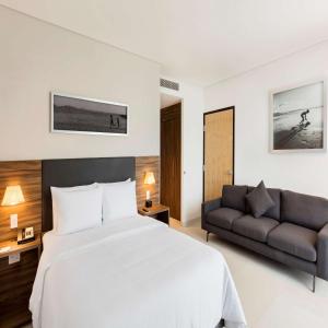 - une chambre avec un grand lit et un canapé dans l'établissement Hampton Inn By Hilton Cancun Cumbres, à Cancún