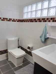 a bathroom with a white toilet and a sink at Karon Holiday Home by Bcare in Karon Beach