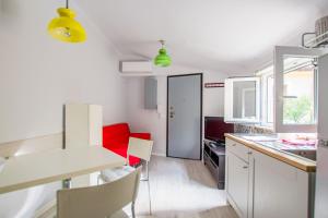 una cucina con un tavolo e un divano rosso di Viale 24 a Trieste Altre 3 foto