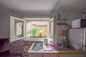 una piccola cucina con lavello e finestra di Viale 24 a Trieste