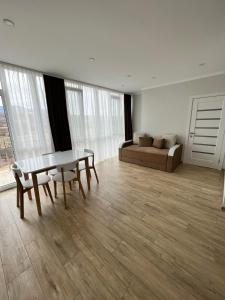 uma sala de estar com uma mesa e um sofá em Sunny apartment в ЖК Сонячний Квартал em Golubinoye