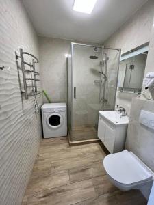 a bathroom with a shower and a toilet and a sink at Sunny apartment в ЖК Сонячний Квартал in Golubinoye
