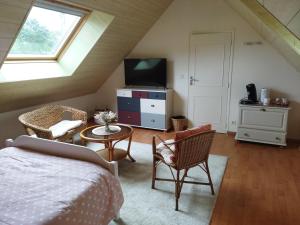 a bedroom with a bed and a tv and a table at Chambre chez l'habitant in Les Portes du Coglais