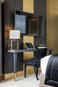 - un bureau avec un ordinateur portable et une chaise dans la chambre dans l'établissement Niepce Paris, Curio Collection By Hilton, à Paris
