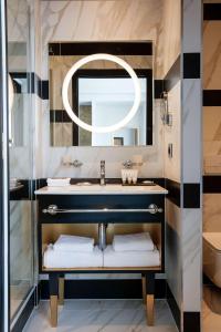 een badkamer met een wastafel en een spiegel bij Niepce Paris, Curio Collection By Hilton in Parijs