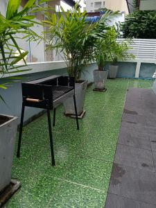 a black piano sitting on a green floor with plants at Karon Holiday Home by Bcare in Karon Beach