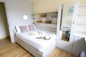 una piccola camera da letto con letto e specchio di Corrib Village Rooms University of Galway a Galway