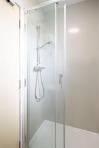 um chuveiro com uma porta de vidro na casa de banho em Corrib Village Rooms University of Galway em Galway