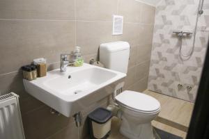 a bathroom with a sink and a toilet at Madison Vendégház 2 in Kisvárda