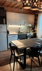 eine Küche mit einem Tisch und eine Küche mit einem Kühlschrank in der Unterkunft Rukanhelmi jr. in Ruka