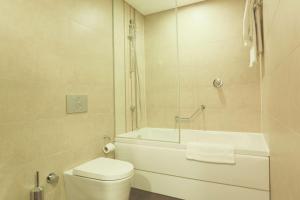 ein Badezimmer mit einem WC, einer Badewanne und einem Waschbecken in der Unterkunft Hilton Garden Inn Eskisehir in Eskisehir
