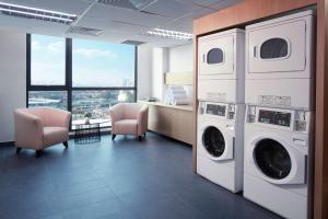 uma lavandaria com duas máquinas de lavar e secar roupa em Hilton Garden Inn Puchong em Puchong