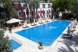 博德魯姆的住宿－DoubleTree by Hilton Bodrum Marina Vista，享有带椅子的大型蓝色游泳池的顶部景致
