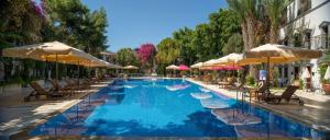 una gran piscina con sillas y sombrillas en DoubleTree by Hilton Bodrum Marina Vista, en Bodrum City