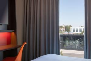 a room with a window with a view of a city at Hampton by Hilton Ashford International in Ashford