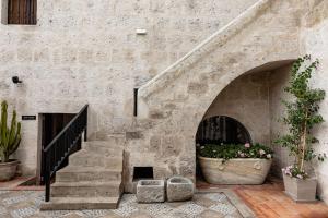 a stone building with a staircase and a pot of flowers at Hampton by Hilton Arequipa in Arequipa