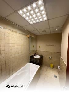 a bathroom with a large tub and a sink at Alphatel Beach Hostel JBR in Dubai