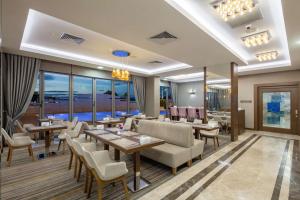 um restaurante com mesas, cadeiras e janelas em Hampton by Hilton Canakkale Gelibolu em Galípoli